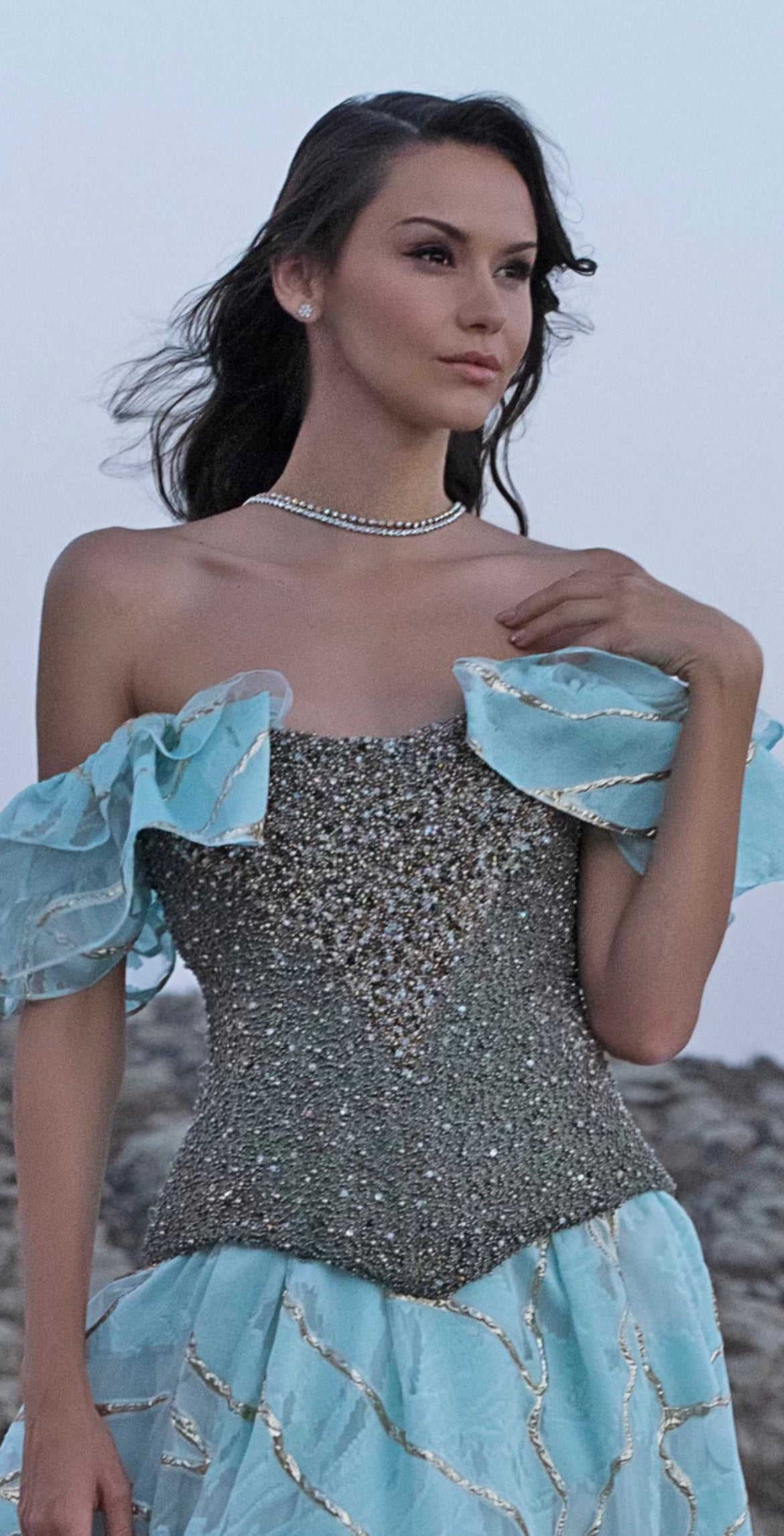 Light-skinned woman outside wearing a Maya corset with a blue skirt.