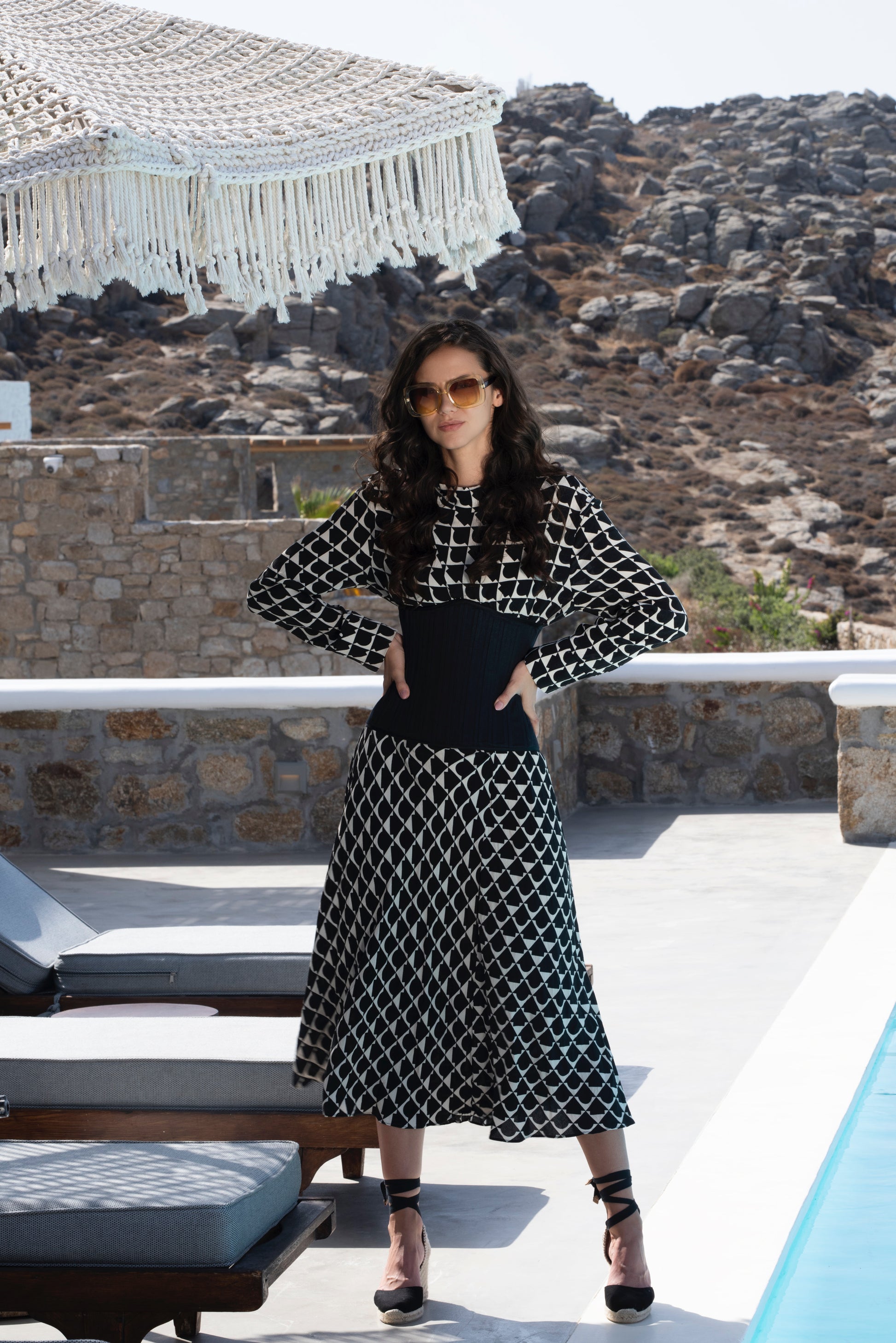 Light-skinned woman wearing a Mila corset over a black and white geometric patterned dress. 